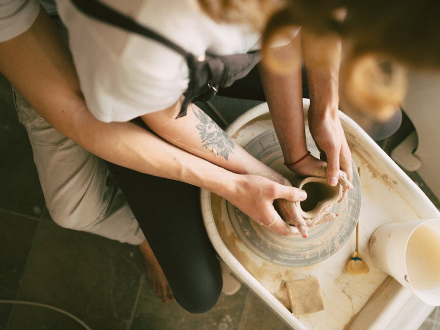 Hands shaping clay on a pottery wheel at Vojejee studio